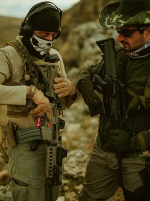 Two military men in tactical gear with firearms during training in Türkiye outdoors.