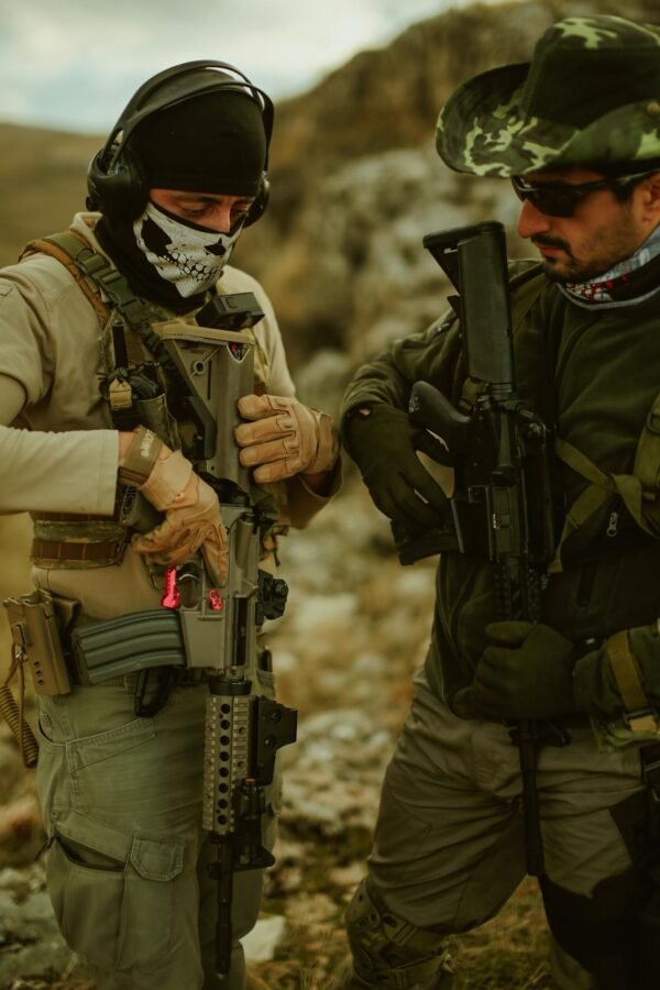 Two military men in tactical gear with firearms during training in Türkiye outdoors.