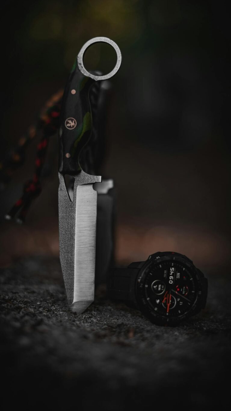 A survival knife with a tactical wristwatch set on rocks in a forest setting, showcasing outdoor adventure gear.