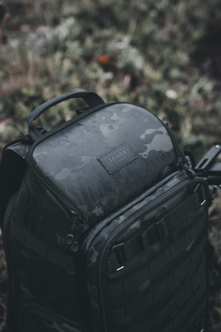 Close-up of a Tenba camouflage backpack outdoors, showcasing rugged design.